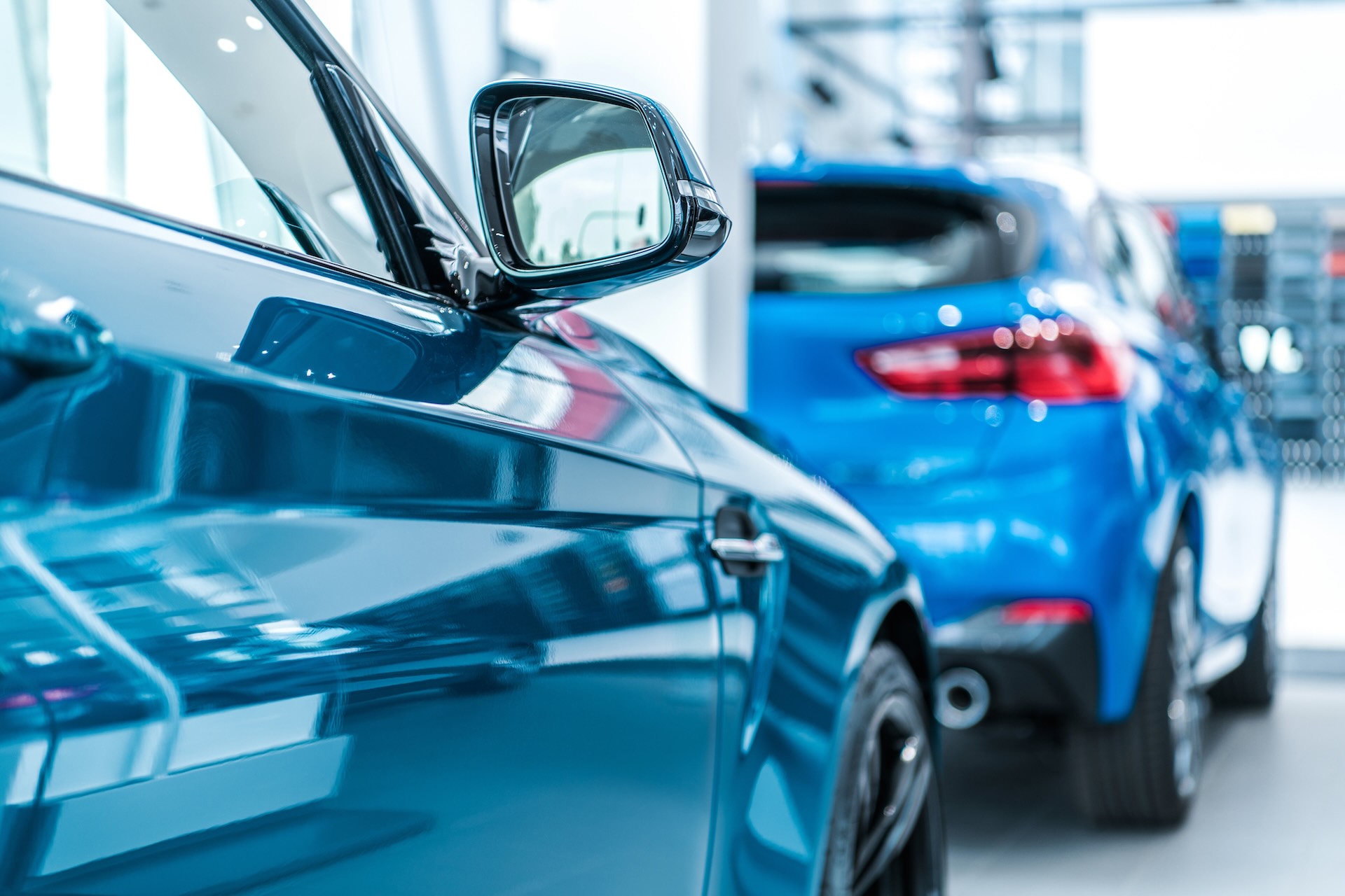 Blue vehicles lined up inside a bright Massy Motors showroom