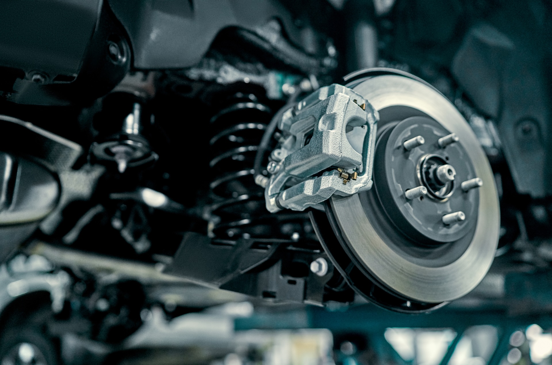 Close-up of a vehicle brake disc and suspension in the service workshop